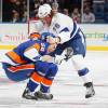 UNIONDALE, NY - JANUARY 21: Joe Finley #52 of the New York Islanders gets tangled up with Pierre-Cedric Labrie #76 of the Tampa Bay Lightning at Nassau Veterans Memorial Coliseum on January 21, 2013 in Uniondale, New York.  (Photo by Mike Stobe/NHLI via Getty Images)